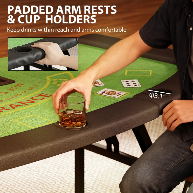 Person holding a glass of whiskey on a gaming table with padded arm rests and cup holders.